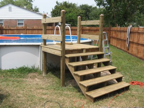1994 Ford Bronco - A wooden deck and stairs provide access to an above-ground swimming pool on a sunny day.