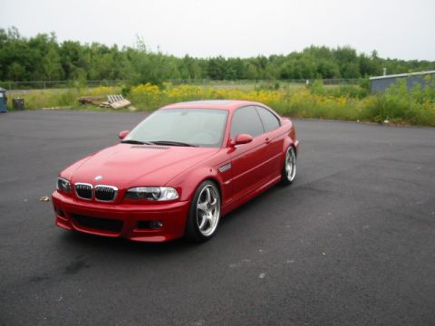 1998 Ford Crown Victoria - Red BMW E46 M3 coupe parked outdoors on a cloudy day.