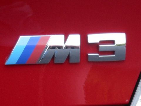1998 Ford Crown Victoria - The "M3" emblem with BMW's signature M stripes is shown on a red car's body.