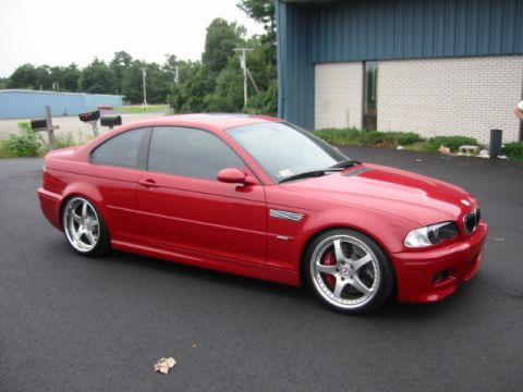 1998 Ford Crown Victoria - A red BMW M3 coupe is shown from a three-quarter front angle, parked on an asphalt surface.