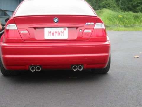 1998 Ford Crown Victoria - Rear of a red BMW M3 coupe with dual twin exhaust tips and a Massachusetts plate MWMWM, parked on pavement.