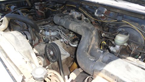 1989 Ford Bronco - Close-up view of an engine bay, showing various mechanical parts and hoses.