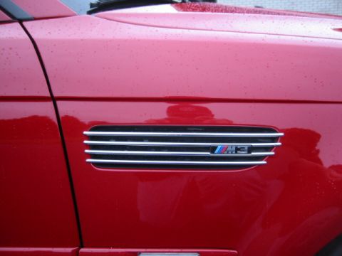 1998 Ford Crown Victoria - Side vent with M3 badge on a red vehicle.