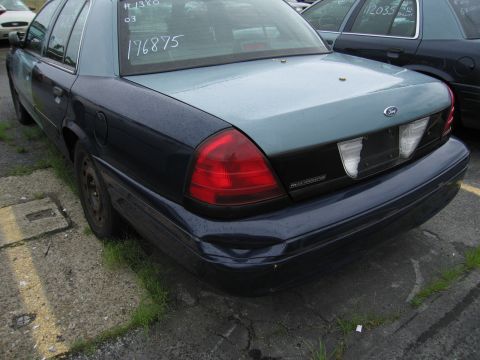 2001 Ford Crown Victoria - A 2001 Ford Crown Victoria is parked in a lot with another vehicle visible.