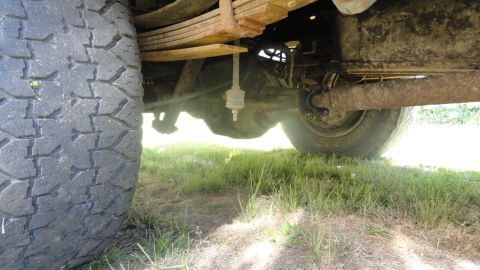 1989 Ford Bronco - Undercarriage view showing the rear axle, leaf springs, and tire of a vehicle.