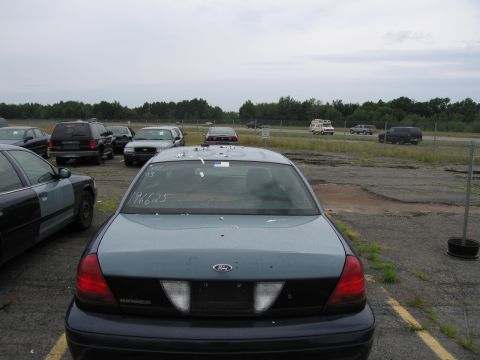 2001 Ford Crown Victoria - A 2001 Ford Crown Victoria is seen from the rear in a parking lot with other vehicles.