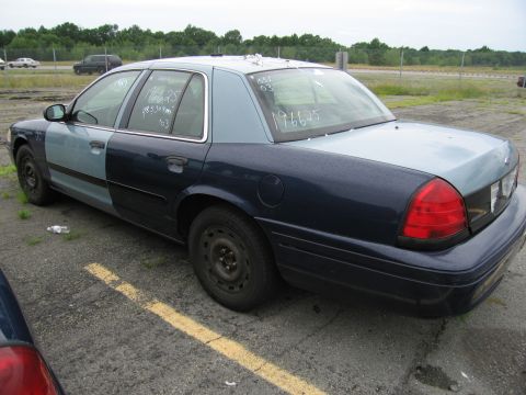 2001 Ford Crown Victoria - Ford Crown Victoria with handwritten numbers on windows, parked in a lot.