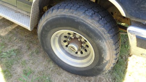 1989 Ford Bronco - Detail shot of a vehicle's wheel and fender area, showing a diamond plate step.