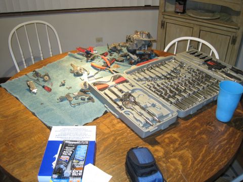 1979 Ford Bronco - Engine parts and tools are spread across a table, ready for assembly or repair.