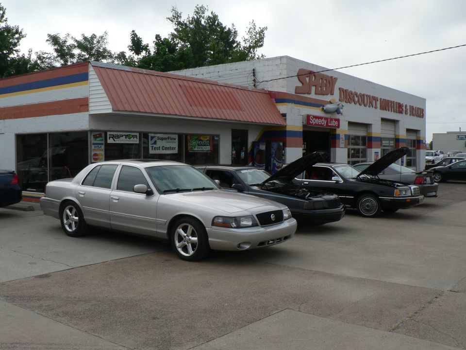 Silver 2004 Mercury Marauder parked in front of a Speedy Mufflers shop with other cars nearby
