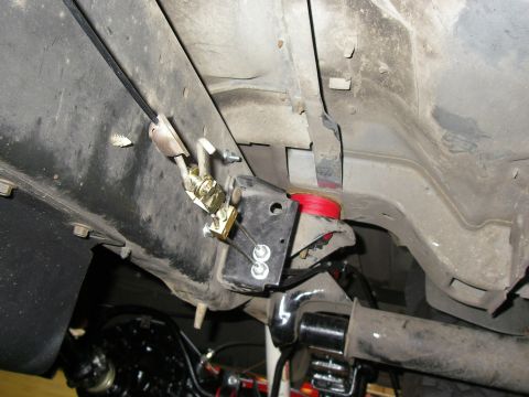 1990 Ford Bronco - Close-up of vehicle undercarriage components, focusing on suspension and brake lines.