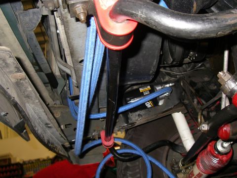 1990 Ford Bronco - Close-up of the undercarriage showing various mechanical components and blue hoses.