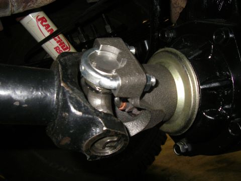 1990 Ford Bronco - Close-up of a vehicle's driveshaft U-joint and a Rancho shock absorber.