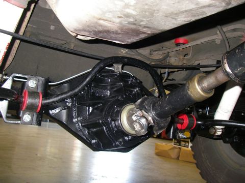 1990 Ford Bronco - Undercarriage view of a vehicle's rear axle, driveshaft, and suspension parts.