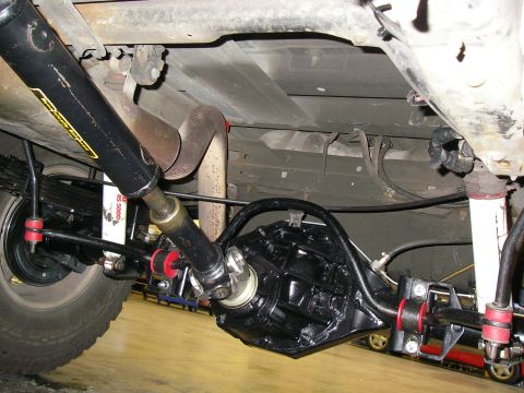 1990 Ford Bronco - Close-up view of the rear axle assembly and suspension of a vehicle, highlighting custom modifications.