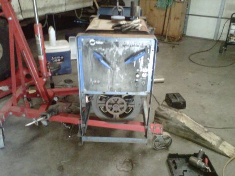 1994 Ford F-150 - A welding machine sits in a garage, surrounded by tools and equipment.