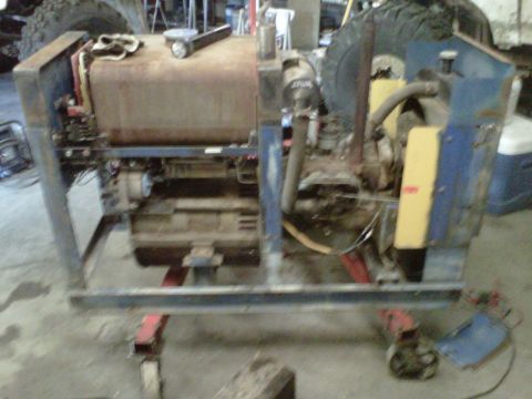 1994 Ford F-150 - This generator set features a large rusty fuel tank and a blue metal housing, mounted on a frame with wheels.