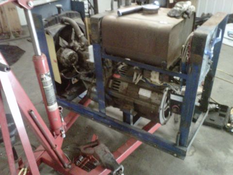 1994 Ford F-150 - Engine and generator assembly mounted on a frame, with a red engine hoist in the foreground.