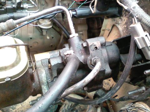 1990 Ford Bronco - Close-up view of engine components, including power steering and brake fluid reservoir, in an engine bay.