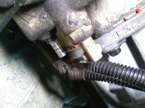 1990 Ford Bronco - Detail of an engine part with a connected hose, likely from a vehicle's mechanical system.