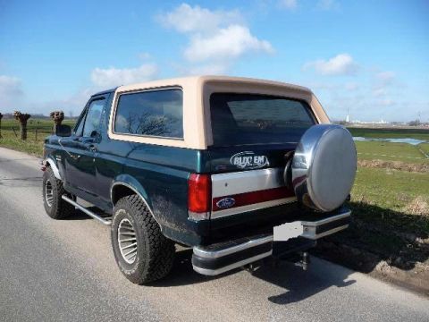 1988 Ford Bronco - This 1988 Ford Bronco is seen from the rear, its distinctive tan removable top and a spare tire mounted on the tailgate.