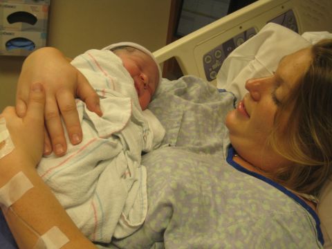 2008 Ford F-250 - A mother lovingly holds her newborn baby shortly after birth in a hospital room.