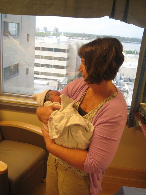 2008 Ford F-250 - A woman cradles a newborn baby while looking out a hospital window at the city skyline.