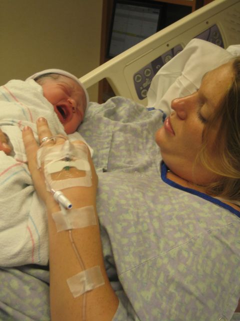2008 Ford F-250 - A mother looks at her newborn baby in a hospital bed, with medical equipment visible.
