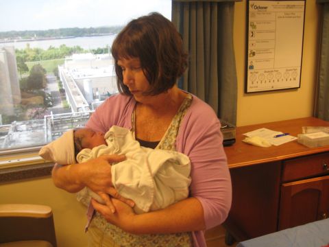2008 Ford F-250 - A woman holds a newborn baby in a hospital room, with a view of the outside world through the window.