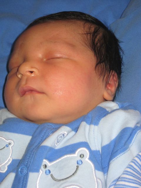 2008 Ford F-250 - A close-up of a sleeping newborn baby's face, dressed in striped pajamas.