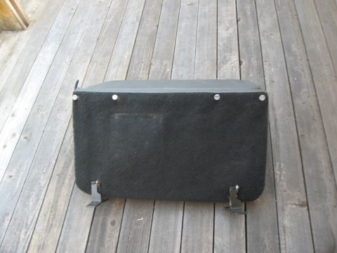 1986 Ford Bronco - A black car seat base with metal mounting brackets is shown resting on a wooden deck.