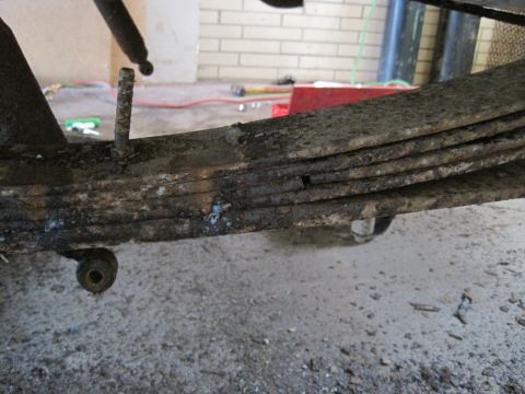 1979 Ford Bronco - Rusty leaf spring assembly, likely from an older vehicle, showing signs of wear and tear.
