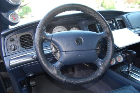 1985 Mercury Grand Marquis - Interior view of a car with custom gauges and a steering wheel a Mercury emblem.