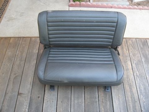 1986 Ford Bronco - A single vehicle seat with a ribbed pattern is shown resting on a wooden deck.