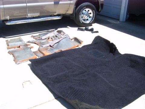 1973 Ford Ranchero - Old carpet and sound deadening material removed from a vehicle sits on the ground.