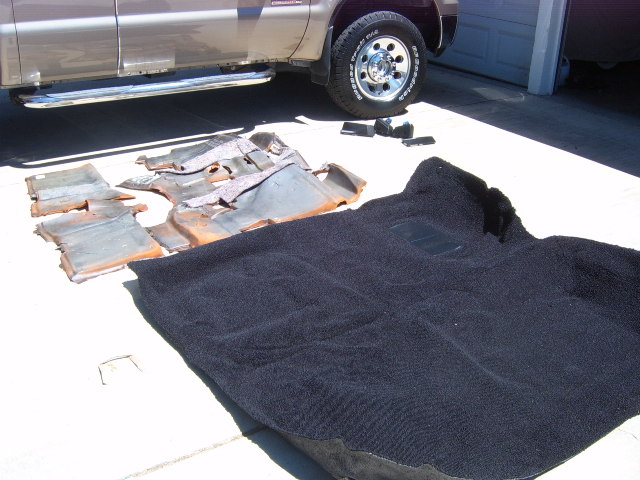 Carpet and insulation pieces laid out on concrete next to a truck