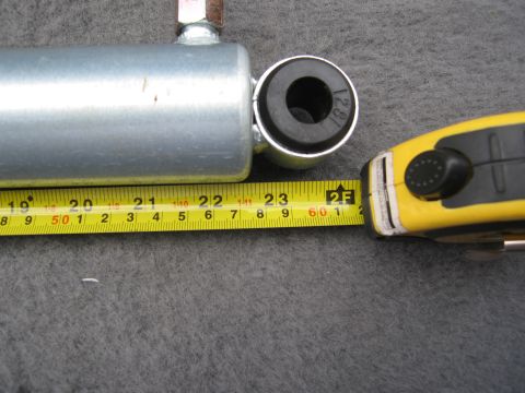 1986 Ford Bronco - A shock absorber is measured with a tape measure, showing its length.