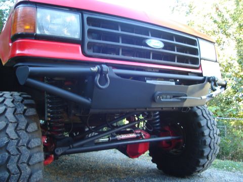 1989 Ford Bronco - Front view of a red 1989 Ford Bronco, a custom bumper with a winch and tow hooks.