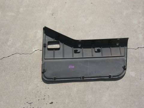 1986 Ford Bronco - A black Jeep door panel is shown lying on a concrete surface, with purple markings visible on its surface.