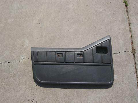 1986 Ford Bronco - A single vehicle door panel is shown lying on a concrete surface.
