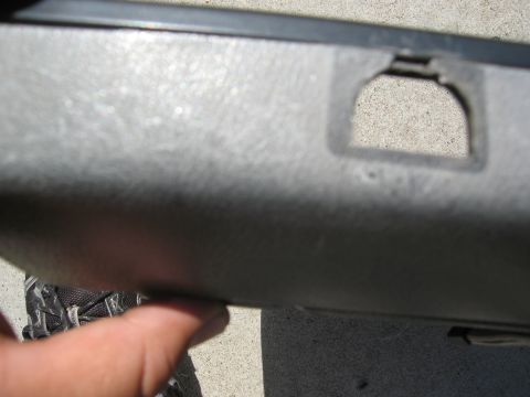 1986 Ford Bronco - Detail of a vehicle's interior door panel, showing a textured surface and a shaped opening.