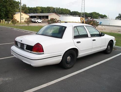 White sedan parked in a lot. The rear of the car is visible