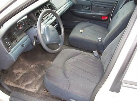 1999 Ford Crown Victoria - The interior of a sedan shows a worn dashboard and seats, with a visible 'Supermotors.net' watermark.
