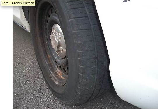 Close-up of a flat tire on a vehicle, showing the steel wheel and hubcap