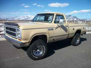 2006 Ford E350 - This 1985 Dodge Ram pickup truck is shown from the front three-quarter view with a mountainous landscape behind it.