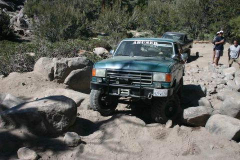 1991 Ford Bronco - This Ford F-Series truck is navigating a rocky trail with another vehicle following behind.