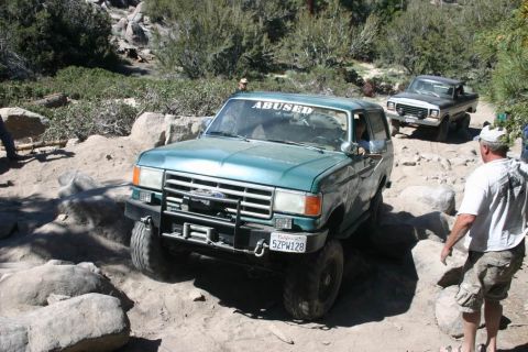1991 Ford Bronco - 1991 Ford Bronco tackling a challenging rocky trail with another vehicle following.