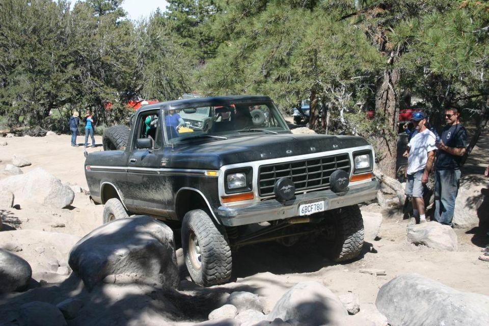 Black Ford Bronco off-roading over rocks. License plate reads 6BCF780