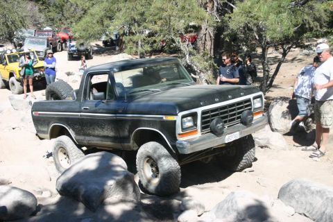 1991 Ford Bronco - This Ford Bronco navigates a rocky trail with other vehicles in the background.