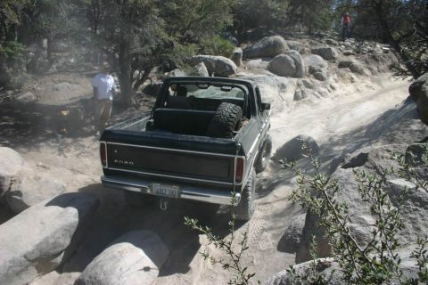 1991 Ford Bronco - Ford Bronco tackling a challenging rocky trail, spare tire mounted in the cargo area.